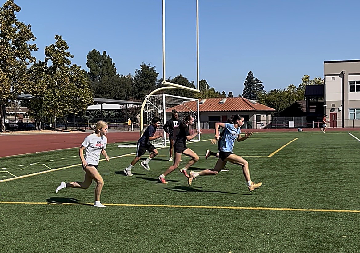 Boys and girls sprinting together during a co-ed speed and agility session at Cal State East Bay in Hayward
